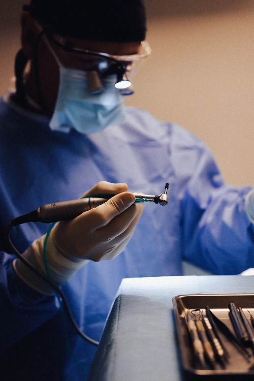 Dentiste chirurgien manipulant un implant dentaire